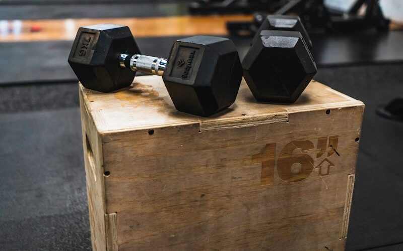 black and gray dumbbells on brown wooden crate